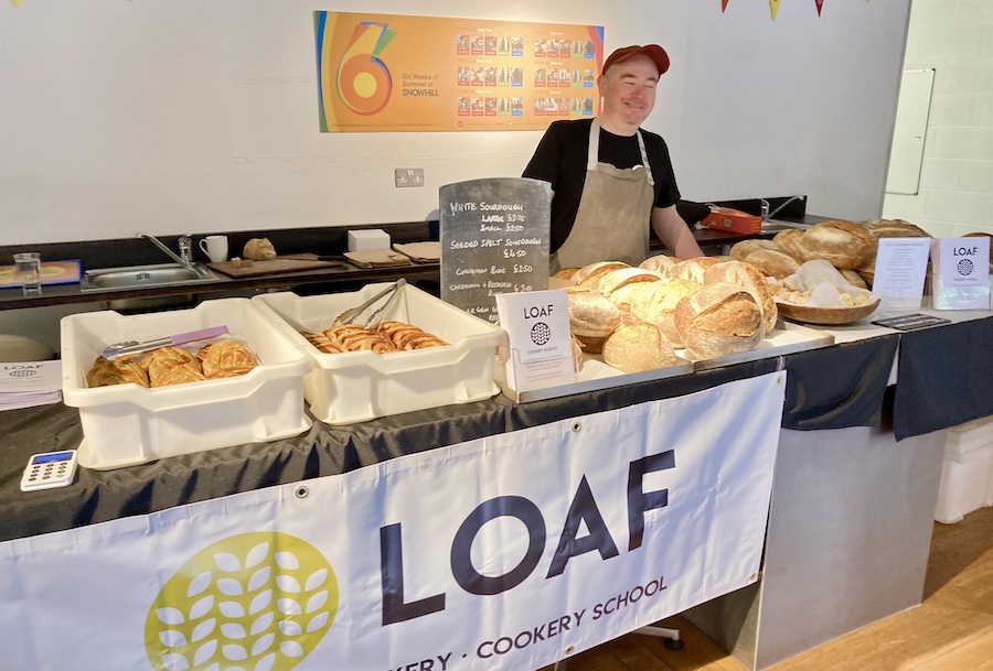 Loaf's stall at Six Weeks of Summer, with Neil standing behind a display of bread and pastries.
