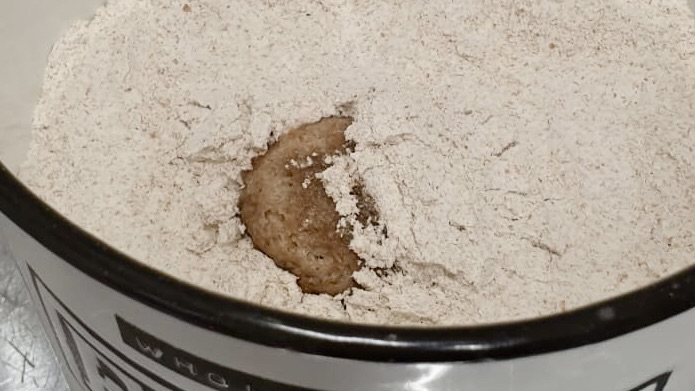 Desem sourdough ball peeking out of the flour