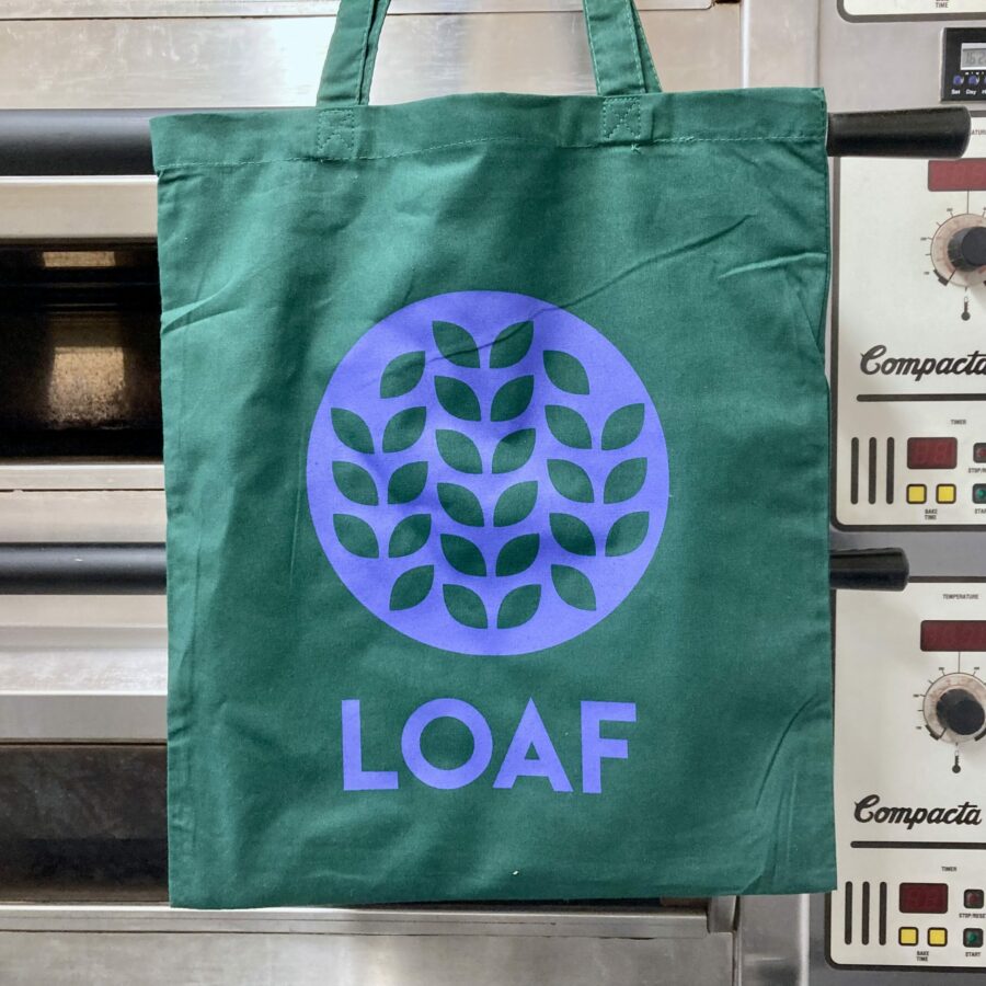 A green tote bag with the Loaf logo